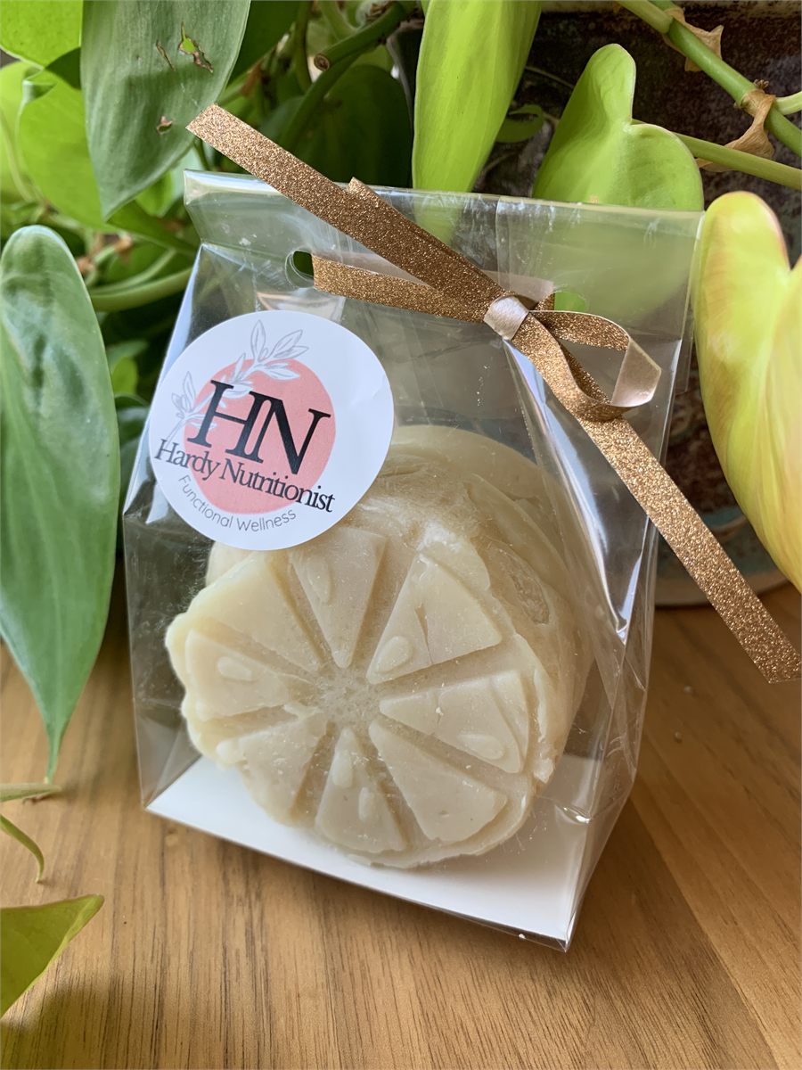 A citrus-molded soap bar in a clear gift bag tied with a gold ribbon, with a round Hardy Nutritionist sticker.